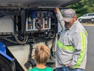 Worker talking to kid with Miles the Sweeper Truck